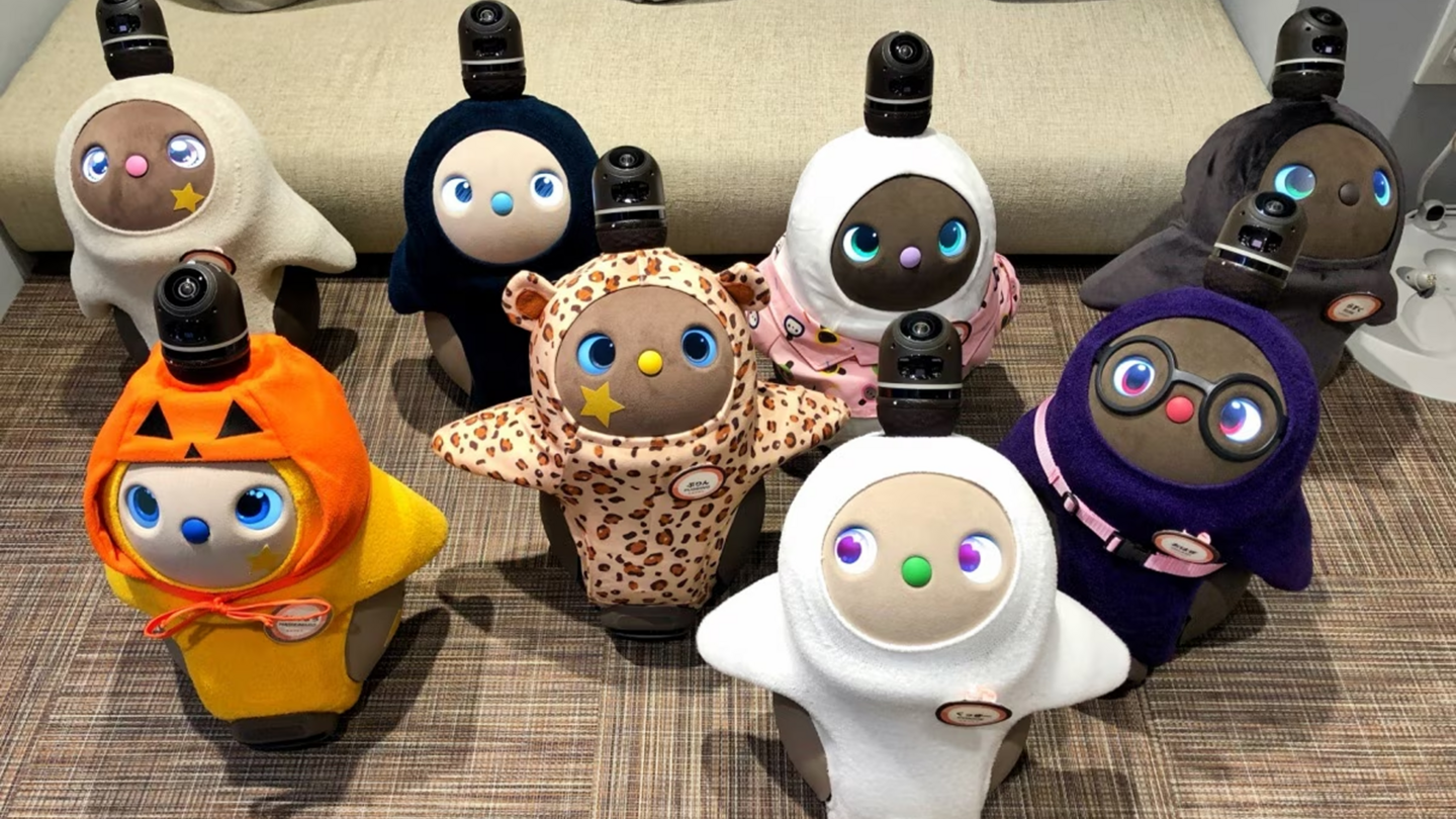 A group of colourful Lovots in costumes at Tokyo's LOVOT cafe