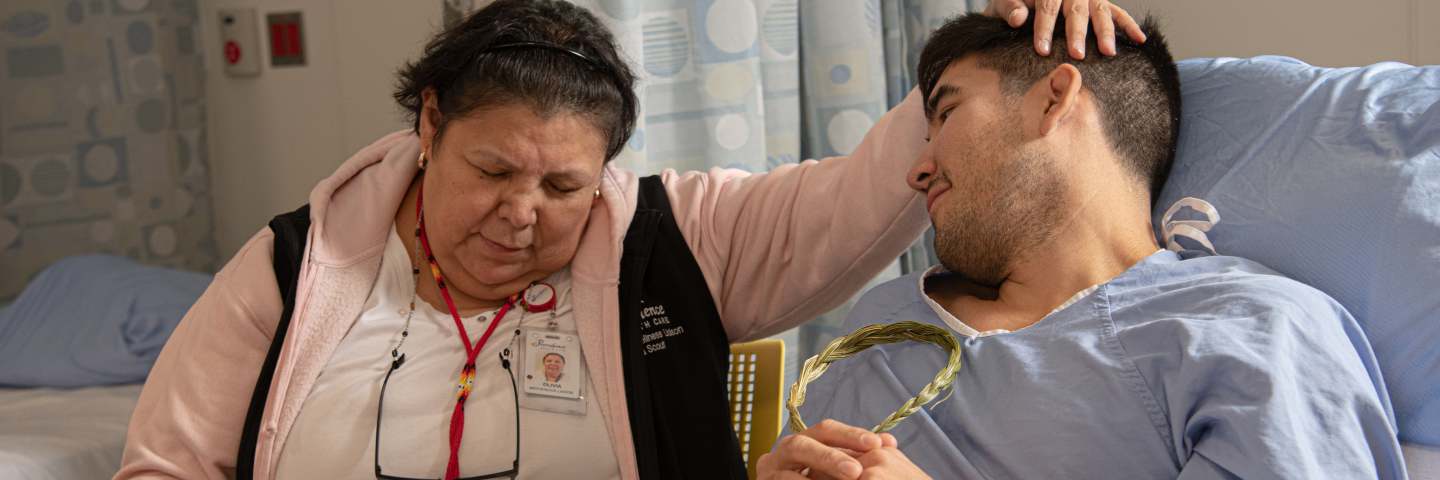 A woman puts her hand on a sick patient's head