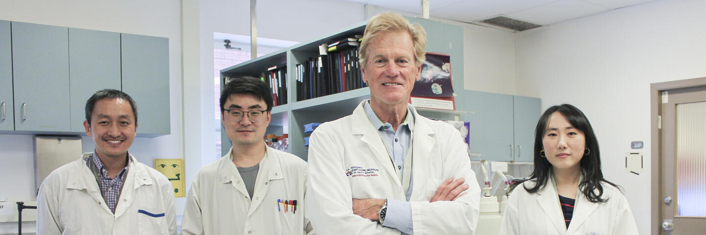 A group of people in lab coats stand in a line