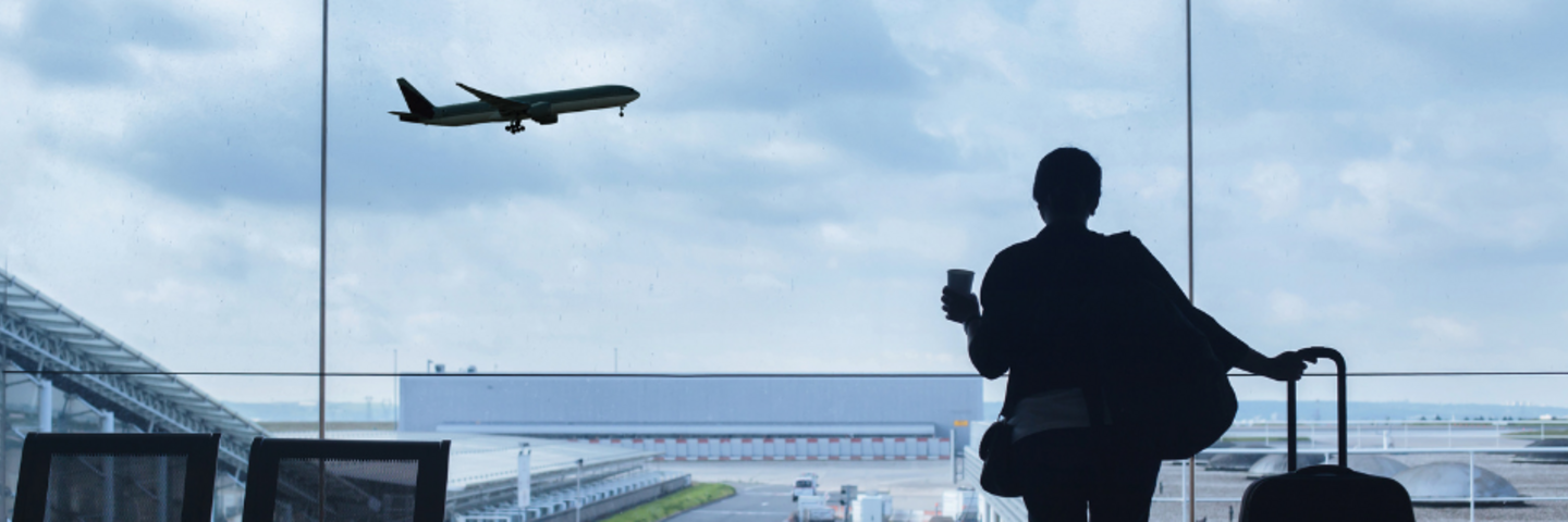 Passenger looking at a plane take off from an airport