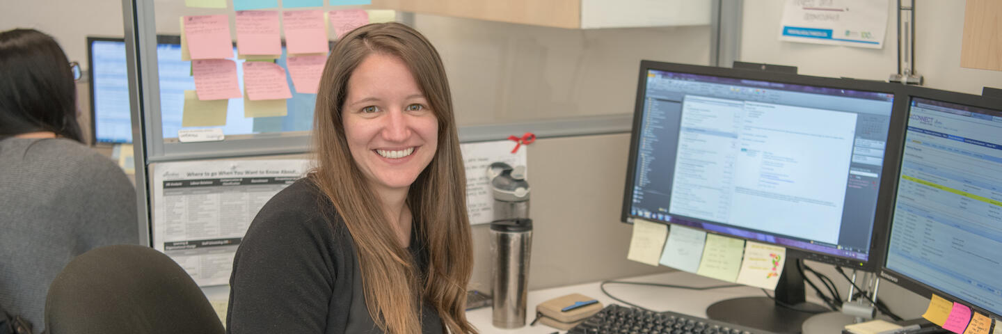 A woman sits at a desk in an office