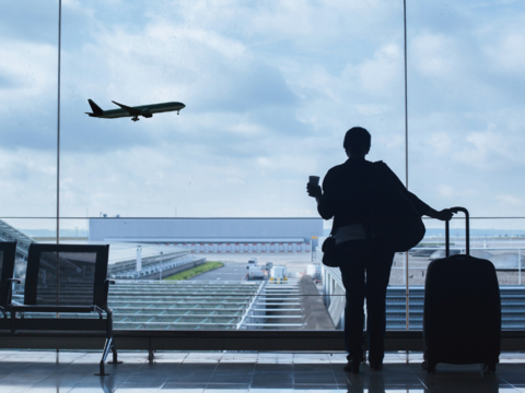Passenger looking at a plane take off from an airport